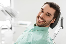A happy, smiling man sitting in a dentist’s chair