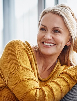 Woman in yellow sweater smiling confidently