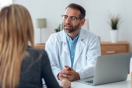 dentist talking to patient about TMJ treatment  